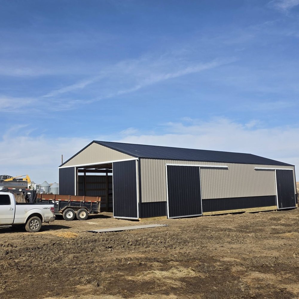 A tan and charcoal shop with sliding doors and a pickup parked outside